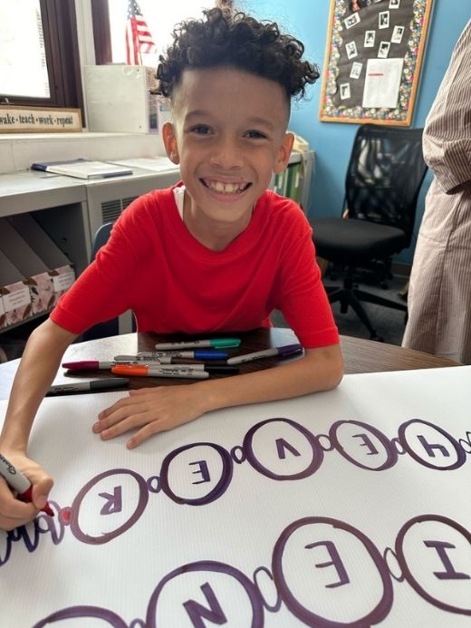 Young boy smiling working on an art project