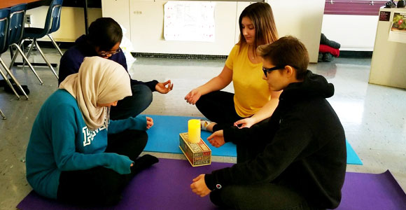 Four students practicing yoga